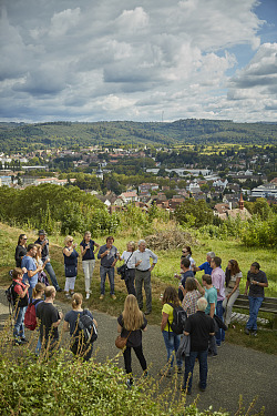 Das Bild zeigt im Vordergrund die Teilnehmer der Weinbergführung auf dem Schutterlindenberg zusammen mit Hans Wöhrle vom Weingut Wöhrle. Im Hintergrund der Blick über Lahr. 
