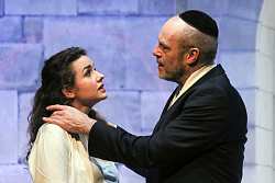 Das Szenenfoto zeigt Nathan den Weisen zusammen mit einer Frau. Sie sprechen miteinander während er mit beiden Händen ihre Schultern hält.