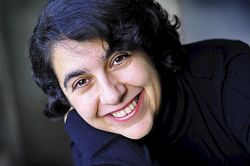 Lächelnde Frau mit braunen Augen und halblangen, schwarzen, welligen Haaren