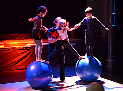 Der Kinder- und Jugendzirkus "LahriFahri" gastiert im Schlachthof Lahr. Auf dem Bild balancieren zwei Kinder auf großen Gmynastikbällen. Ein Mädchen balanciert zwischen den Bällen. 
