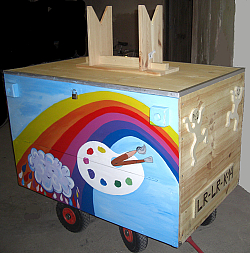 Der mobile Spielwagen des Bürgerzentrums Kanadaring ist aus Holz gebaut und mit einem Regenbogen und einer Farbpalette kindgerecht bemalt. 