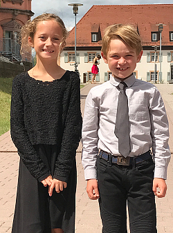 Die Lahrer Musikschüler Laura Krieg rechts und Romeo Klassen waren beim Elias Corinth-Klavierwettbewerb in Karlsruhe erfolgreich.
Beide lächeln in die Kamera. die blonde neunjährige Laura träft ein schwarzes Kleidchen mit langarmigen Spitzenoberteil. Der blonde achtjährige Romeo trägt ein hellgraues Hemd mit dunkelgrauer Krawatte. 