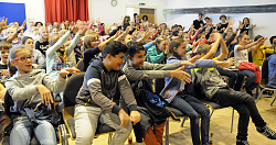 Publikum aus Kindern hebt freudig die Hände nach Vorne