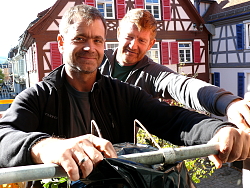 Zwei Mitarbeiter der Lahrer Bau- und Gartenbetriebe hängen am Alten Rathaus der Stadt Lahr Kaskadenchrysanthemen auf. 