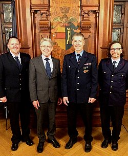 Auf dem Bild gruppieren sich von links der Vorsitzende des Kreisfeuerwehrverbandes Michael Wegel, Oberbürgermeister Dr. Wolfgang G. Müller, der ehemalige stellvertretende Kommandant Alfred König und Kommandant Thomas Happersberger im alten Ratssaal im Alten Rathaus.  