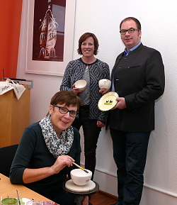 Für die Chrysanthema 2017 präsentieren von links Martina Mundinger von der Stadt Lahr, Ralf Müller, Geschäftsführender Gesellschafter der Zeller Keramik Manufaktur das neue Chrysanthemasouvenier.
Davor sitzt Kerammalerin Erika Börsig und malt an einem Schälchen mit altrose Chrysanthemen. 