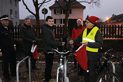 Die Stadt Lahr hat zusammen mit dem Polizeirevier Lahr eine Aktion zur richtigen Fahrradbeleuchtung durchgeführt. 
Ein Herr mit gelber Warnweste und roter Zipfelmütze übergibt einem Schüler ein kleines Schokoladenherz. Die Zwei werden umringt von Felix Neulinger in Polizeiuniform, Bürgermeister Tilman Petters mit gefütterter dicker Jacke und Pelzbesatz und Martin Stehr, in roter Jacke mit roter Weihnachtsmannmütze. Sie stehen auf einem Fahrradparkplatz, umringt von Fahrrädern. 