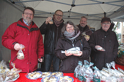 Bei der LichtBlicke-Spendenaktion 2017 der Stadt Lahr haben von links Roland Hirsch, Guido Schöneboom, Christine Breuer und Tilman Petters weihnachtliches Gebäck für einen guten Zweck angeboten.
Die vier stehen unter einem Pavillon hinter einem Tisch, auf dem weihnachtliches Gebäck in Folie verpackt präsentiert wird. Alle vier halten Weihnachtsgebäck in der Hand und lächeln in die Kamera. 