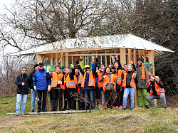 Schüler des Max-Planck-Gymnasium haben sich vor dem Pavillon auf dem Langenhard zu einem Gruppenbild versammelt. Sie alle tragen orangene Warnwesten. 