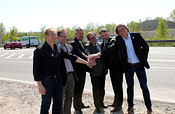 Die Personen stehen im Halbkreis am Autobahnzubringer, im Hintergrund sind fahrende Autos, und ballen in der Mitte die Faust gemeinsam zusammen. &#13;&#10;&#13;&#10;Personen von links nach rechts:&#13;&#10;Udo Gütle; Regierungspräsidium (RP) Freiburg (FR), Bauleitung&#13;&#10;Gerald Schmidt; RP FR Referatsleiter 47.1&#13;&#10;Tilman Petters; Bürgermeister der Stadt Lahr&#13;&#10;&#13;&#10;&#13;&#10;Claus Walther;RP FR Abteilungspräsident (als Vertreter der Regierungspräsidentin)&#13;&#10;Markus Ibert; Geschäftsführer startkLahr&#13;&#10;Udo Lau; Leiter der Abteilung Tiefbau bei der Stadt Lahr&#13;&#10;