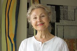 Porträt von Eva Schniedertüns-Gornik, einer grauhaarig freundlich lächelnden Dame im Atelier. 