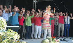Chor mit bunten Hemden, klatschend auf der Bühne