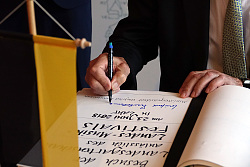 MP Kretschmann zu Besuch in Lahr. Blick auf das goldene Buch, im Monent, als Kretschmann schwungvoll in großen Buchstaben unterschreibt. 