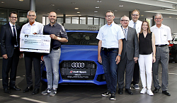 Peter Rottenecker (Volksbank Lahr), Karl Dörflinger (Link.Lahr), Tobias Meinen (Städtische Musikschule Lahr) und die Sponsoren Michael Binder (E-Werk), Waldemar Dixa, (MultiPart), Tanja Wöhrle (Weingut Wöhrle) sowie Erster Bürgermeister Guido Schöneboom und Hans Link (Link.Lahr) haben sich von links nach rechts aufgestellt. Tobias Meinen hält einen großen Spendenscheck in der Hand. Die Gruppe gruppiert sich um einen blauen Audi. &#13;&#10;&#13;&#10;