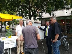 Das Bild zeigt Klimaschutzmanager Dr. Michael Dutschke, Bürgermeister Tilman Petters und Hesso Gantert, Geschäftsführer der Ortenauer Energieagentur, auf dem Lahrer Schloßplatz im Gespräch mit einem interessierten Hausbesitzer.