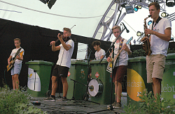 Bild von der Bühne auf der die Musiker der Trashband mit ihren Mülltonnen und ihren Instrumenten stehen und musizieren. 