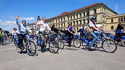 Viele Radfahrer mit Helm fahren auf Pecelecs
