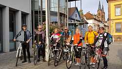 Eine Radlergruppe der Stadt Lahr hat den Oberrhein-Römerradweg erkundet. Sie stellen sich mit ihren Fahrrädern und Helm in Fahrradkluft vor dem Bürgerbüro für das Gruppenfoto auf. 