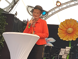 Letzter Tag der Landesgartenschau Lahr.
Staatssekretärin steht an einem Stehtisch auf der Bühne uns spricht in ein Mikro. 