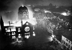 Das Foto zeigt eine brennende Synagoge bei Nacht. 