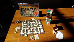 Das Bild zeigt einen Tisch mit verschiedenen Spielen wie Jenga oder einen Würfelbecher mit fünf Würfeln.