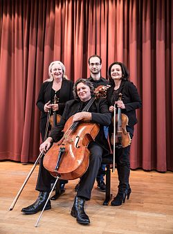 Gruppenbild mit Instrumenten, vorne am Cello sitzt Andreij Melik, hinter ihm links, mit der Violine Anke-Bettina Melik, Mitte Tigran Hakhumyan mit der Viola, rechts Claudia Bühler, Violine