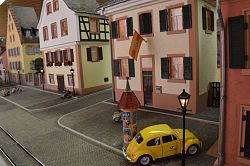 Teil einer Miniatureisenbahn mit Gleisen und Gebäuden.