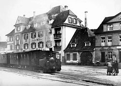 Ein historisches Bild mit einem dampfenden Bähnle vor dem Schlüssel. 