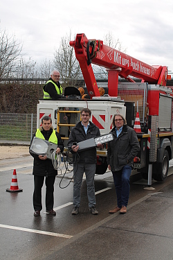 Die Stadt Lahr rüstet auf LED-Leuchten um. 
Auf dem Bild sind von links nach rechts: Von links nach rechts: Lothar Baier (EWM), Philipp Banholzer (Stadt Lahr, Abteilung Tiefbau) und Udo Lau (Stadt Lahr, Leiter Abteilung Tiefbau). Sie stehen vor einem Kranwagen, mit gelben Warnwesten und halten eine Leuchte in der Hand.