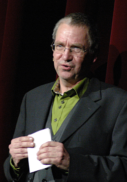 Neujahrsempfang der Stadt Lahr: Moderator Thorsten Mietzner steht auf der Bühne mit grünem Hemd und schwarzen Sakko. 