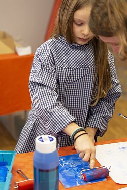 Das Bild zeigt ein kleines Mädchen beim Basteln