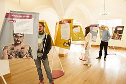 Das Bild zeigt Besucher einer Ausstellung. Sie betrachten die einzelnen Ausstellungsstücke