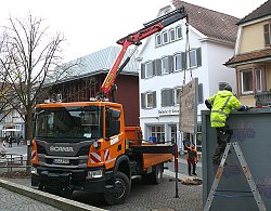 BGL Mitarbeiter bauen die Chrysanthema Häuschen auf dem Urteilsplatz ab. Ein großes bereits abmontiertes Teil der Hütte hängt am Ausleger eines LKW Krans.