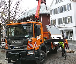 Zu sehen sind zwei BGL Mitarbeiter beim Abbau der Chrysanthema Häuschen auf dem Urteilsplatz. Sie verladen gerade ein großes demontiertes Bauteil mit HIlfe eines Krans auf einen LKW.