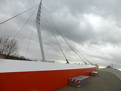 Das Bild zeigt einen Blick auf die Ortenaubrücke, wo zwei provisorische Schwingungstilger stehen. Es sind zwei rechteckige graue Blöcke, an denen rot-weiße Streifen angebracht sind.