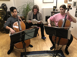Bild: Probe über Kontinente hinweg. Am Cello Dac Anh-Ninh Ngo und Mathilda Meier, gemeinsam mit ihrem Lehrer Andrej Melik der in der Mitte mit einer Partitur in der Hand sitzt. 