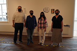 Das Foto zeigt vier Personen, einen Mann und drei Frauen jeweils mit Masken