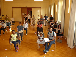Gruppenbild der Absolventinnen und Absolventen der Abendrealschule. Sie sitzen mit viel Abstand im großen Raum verteilt auf Stühlen.