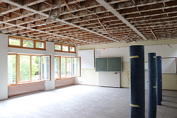 Eines der Klassenzimmer der Schutterlindenbergschule mitten im Umbau. Kabel hängen von der unverkleideteten Decke, Tische und Stühle sind zur Seite geschoben.