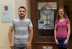 Kufan Kamal Sleiman und Charlotte Wolf stehen vor der Eingangstür des Mehrgenerationenhauses.