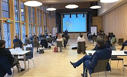 Unternehmerinnen und Unternehmer sitzen bei einem Vortrag im Bürgerhaus Mietersheim.