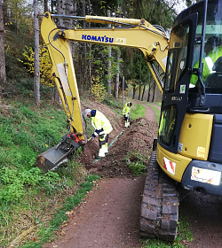Mitarbeiter des Bau- und Gartenbetrieb Lahr bei Arbeiten mit einem Bagger am Ablaufrohr beim Gieseneckbrunnen