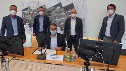 Bürgermeister Pascal Weber (Ringsheim), Bürgermeister Dr. Kai-Achim Klare (Rust), Oberbürgermeister Markus Ibert (Lahr), Bürgermeister Dietmar Benz (Mahlberg) und Bürgermeister Matthias Gutbrod unterschreiben einen offenen Brief an Landrat Frank Scherer im Gemeinderatssaal. OB Ibert sitzt, die anderen stehen drum rum. 