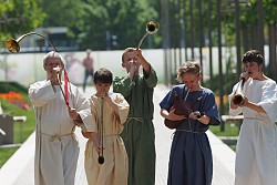Kinder in antiker Kleidung spielen auf römischen Musikinstrumenten.