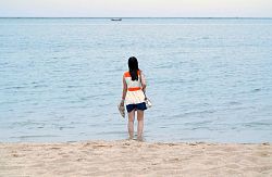 Junge Chinesin von hinten mit dem Gesicht zum Meer