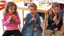 Das Bild zeigt drei Mädchen, die sich testen