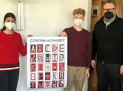 Das Foto zeigt die beiden Schüler zusammen mit dem Ersten Bürgermeister Guido Schöneboom neben der Collage