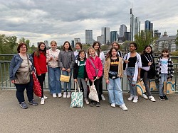 Sabine von Manger-Krämer (links) und Melissa Zucano (Achte von links) mit elf Teilnehmerinnen der Mädchenfreizeit vor der Frankfurter Skyline