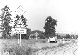 Altes Foto aus Langenwinkel, an der Straße steht ein Verkehrsschild mit dem Hinweis Flugbetrieb