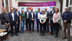 Vertreterinnen und Vertreter der Sponsoren der Chrysanthema stehen vor einer Sponsorenwand. 